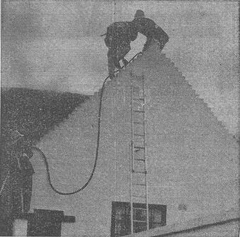 FIREMAN FALLS—Two firemen are seen on the gable-end before one of them, Sub Officer John Haydock, fell as brickwork gave way under him.