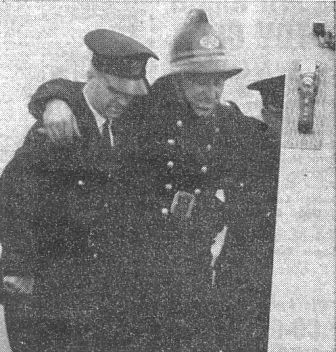 TO HOSPITAL.—Sub Officer Haydock is helped into the ambulance which was called for him after his fall.
